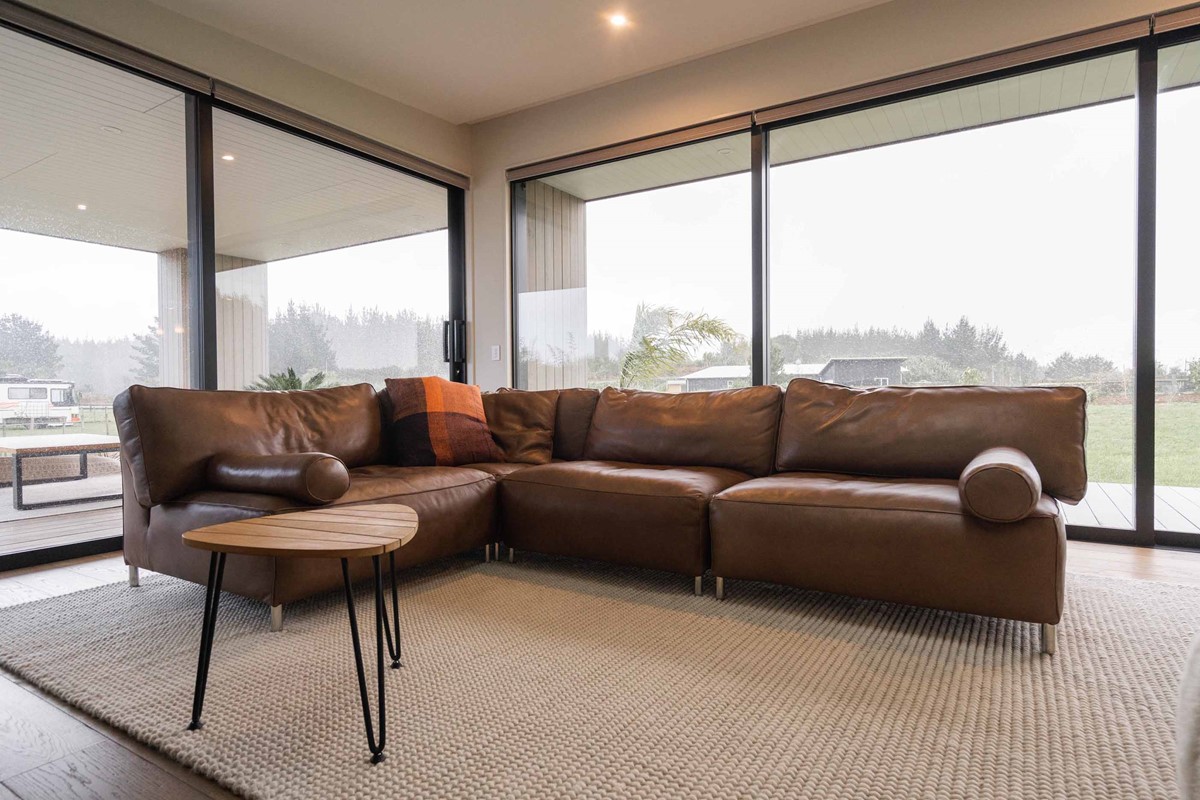 The living area of Tony & Janie's new home, which comes off of the kitchen, also captures the beautiful rural outlook. The beautiful leather couch is just one of the many stunning pieces Tony & Janie purchased for furnish their new home.