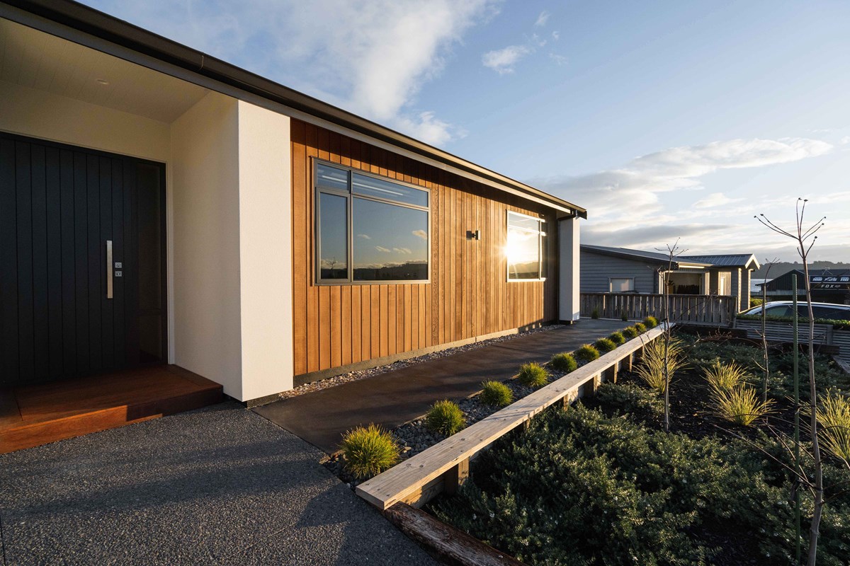 The exterior of the home features dark joinery contrasting to the warm timber cladding. This timber can also be seen within the home as feature walls, creating indoor outdoor consistency.