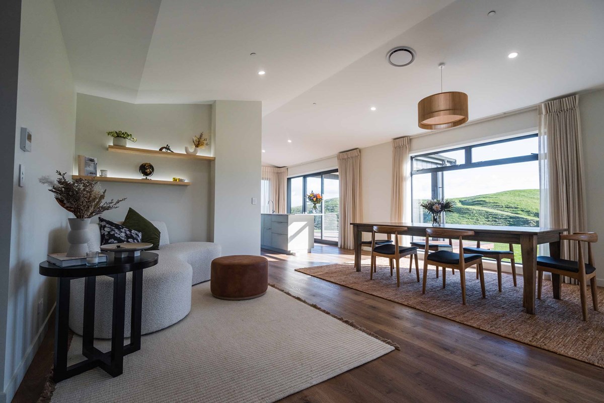 The stunning dining room of Laura and Shaun's home overlooking the green hillside in Hawkes Bay is a great place for their friends and family to gather. Complemented by the reading corner with LED floating shelves to create a focal p