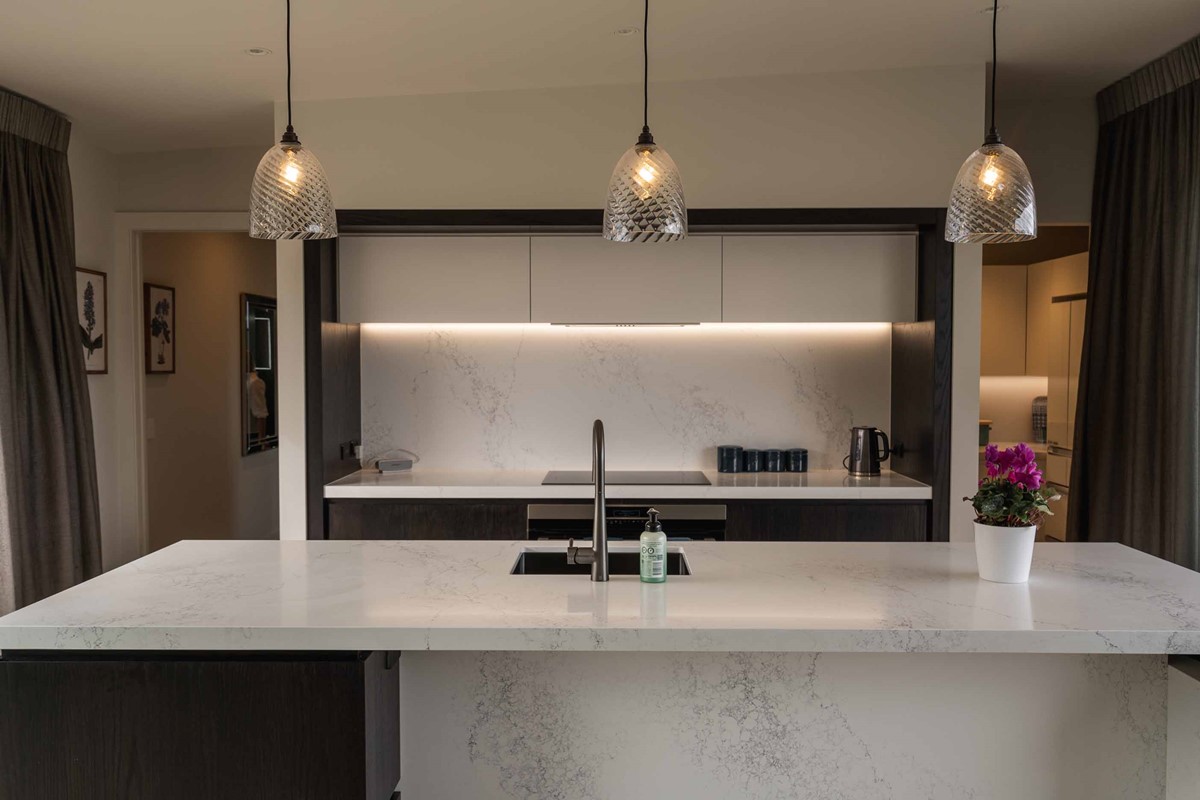 Marie's favourite part of this beautiful home, their kitchen. Stark white upper cabinets contrasting to the deep wood coloured bottom cabinetry that is complemented by the marble benchtop and splashback.