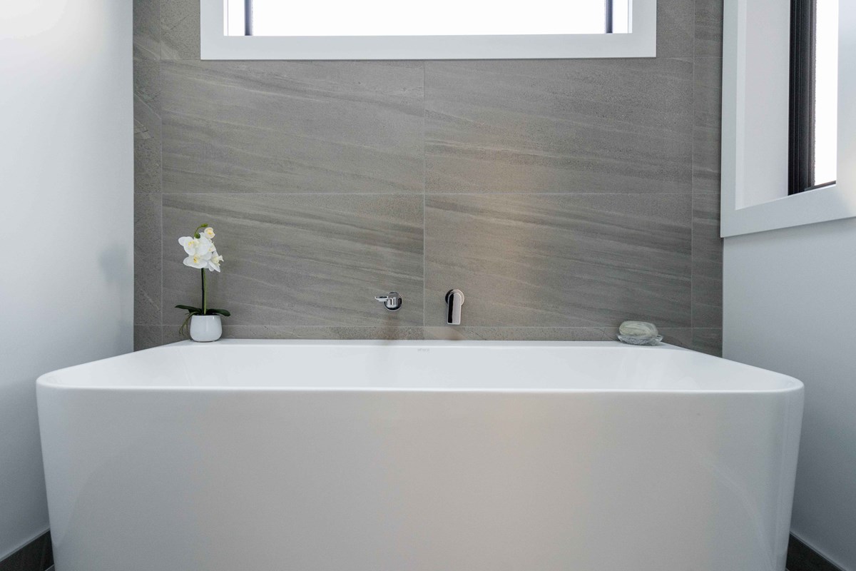 The main bathroom features a freestanding bath and neutral tones.