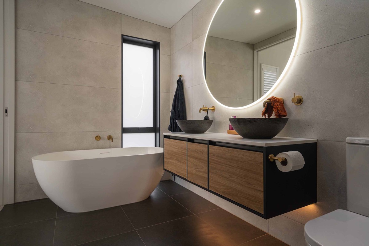 The ensuite of Tony & Janie's new home has been thought out right down to the vanity with the dark charcoal and oak colourings much like their kitchen. The freestanding bath also a hero feature in their ensuite.