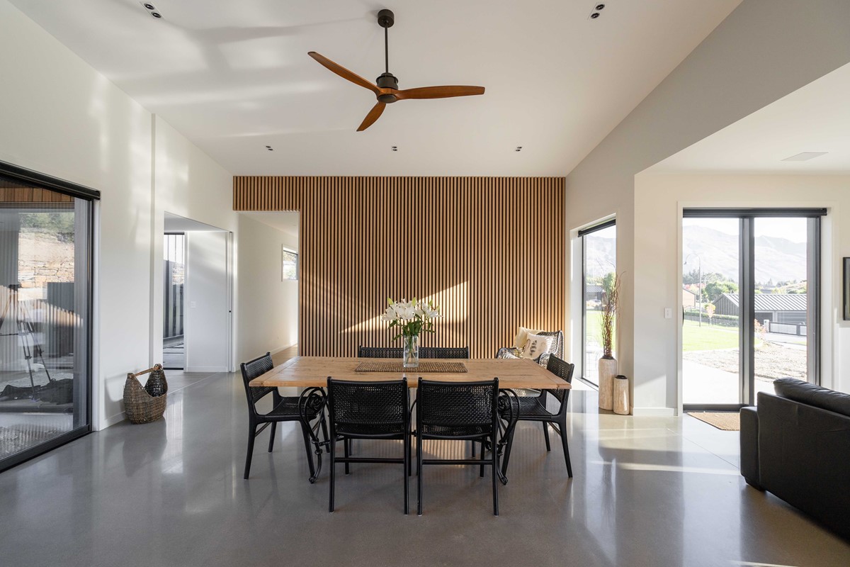 The stunning vertical timber feature wall contrasts beautifully with the polished concrete floors in Colleen & John's dining room. Surrounded by large windows and sliding doors, capturing the sun from all directions, this room is perfect for entertaining guests and enjoying for themselves.